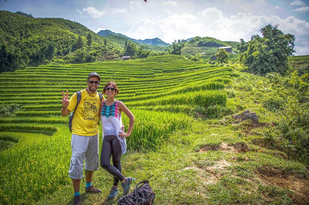 A couple is making a romantic trekking in Sapa through the rice fields while on their honeymoon in Vietnam