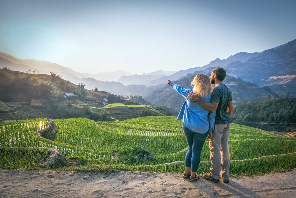 A couple making a romantic trekking in Sapa through terrace rice fields in Vietnam