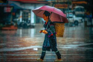 an ethnic minority woman walking through the rain in Sapa