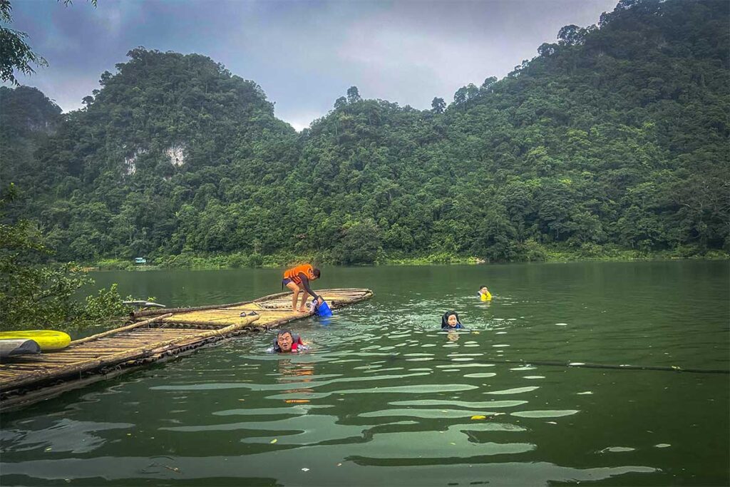 A few travelers swimming with life jackets on in Thang Hen Lake in Cao Bang