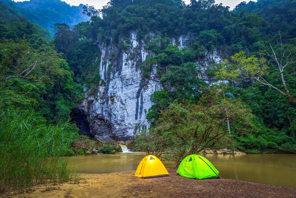 Tents camping at a wild campsite in the middle Phong Nha National Park jungle outside Tu Lan Cave