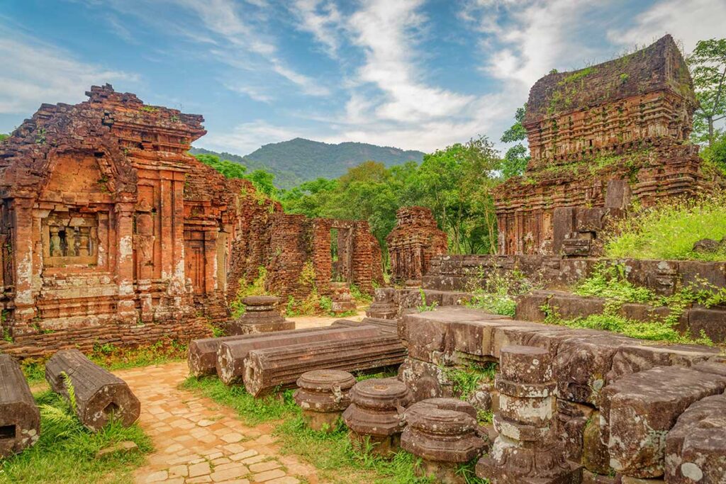 Ancient brick temples surrounded by jungle at My Son Sanctuary – one of the best day trips from Hoi An for history and culture lovers.
