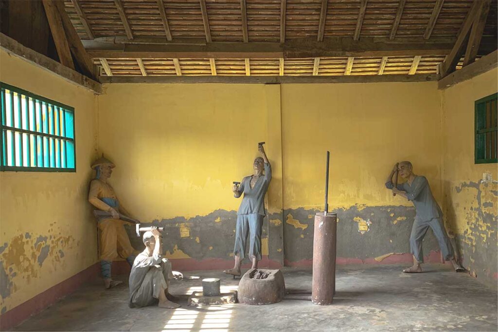 A room inside Ban Me Thuot Colonial Prison featuring exhibits depicting the harsh labor endured by prisoners.