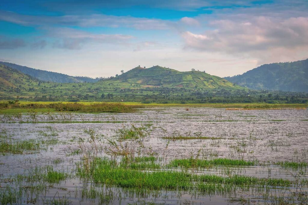 A scenic view of Tien Son Lake, part of Bien Ho Lake, with the distant silhouette of Chu Dang Ya Volcano in the background.