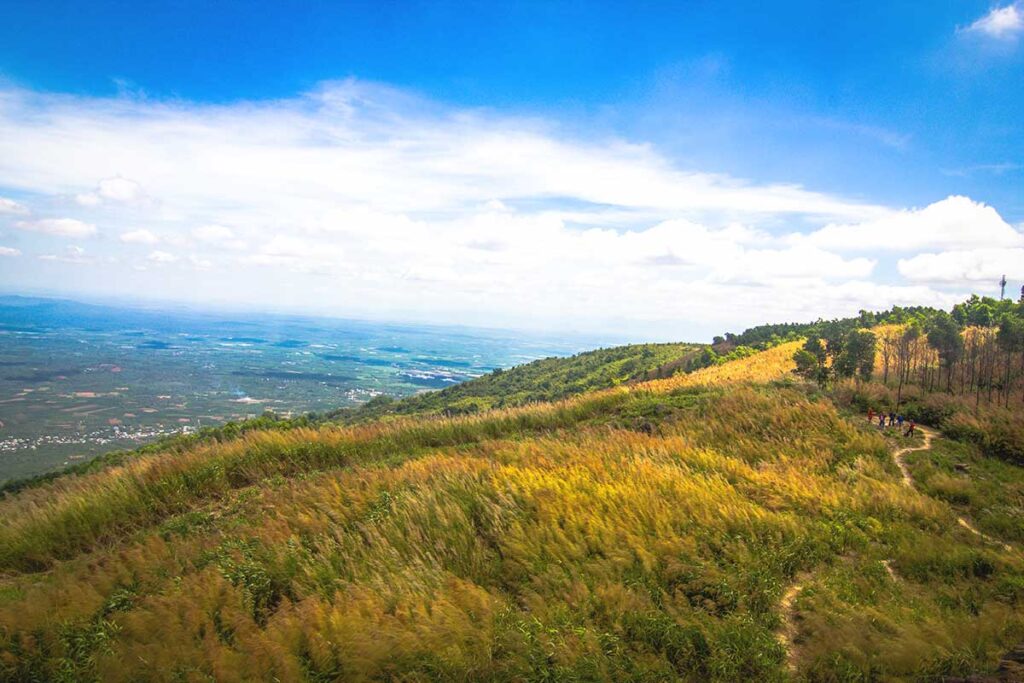 The rolling grassy peak of Chua Chan Mountain, offering panoramic views over the surrounding landscape in Dong Nai Province.