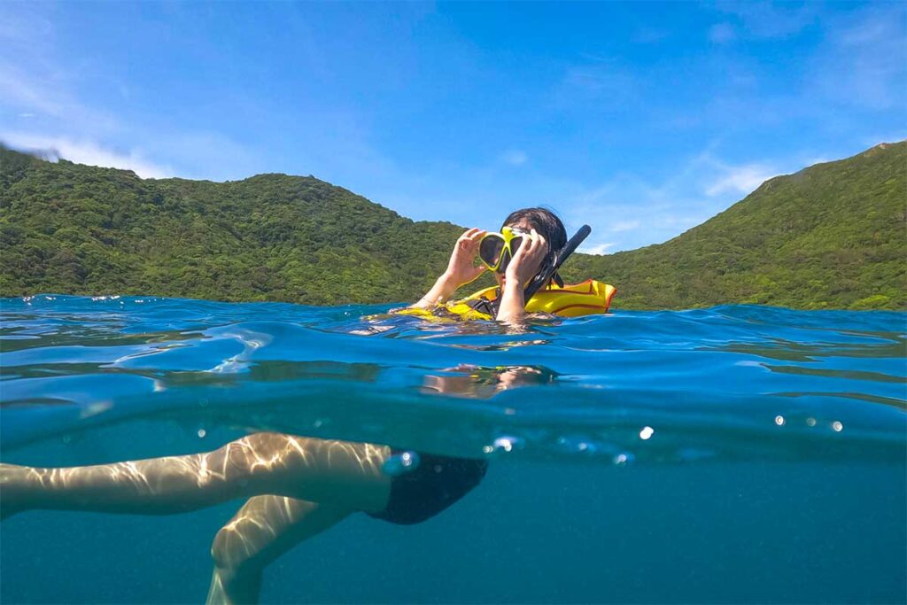 Con Dao in August – A snorkeler explores the waters, taking advantage of the calm sea conditions between rain showers.