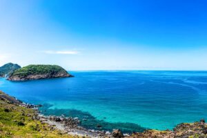 on Dao in December – A stunning small bay with a bright blue sky and light clouds, reflecting the ideal weather conditions at the start of the dry season.