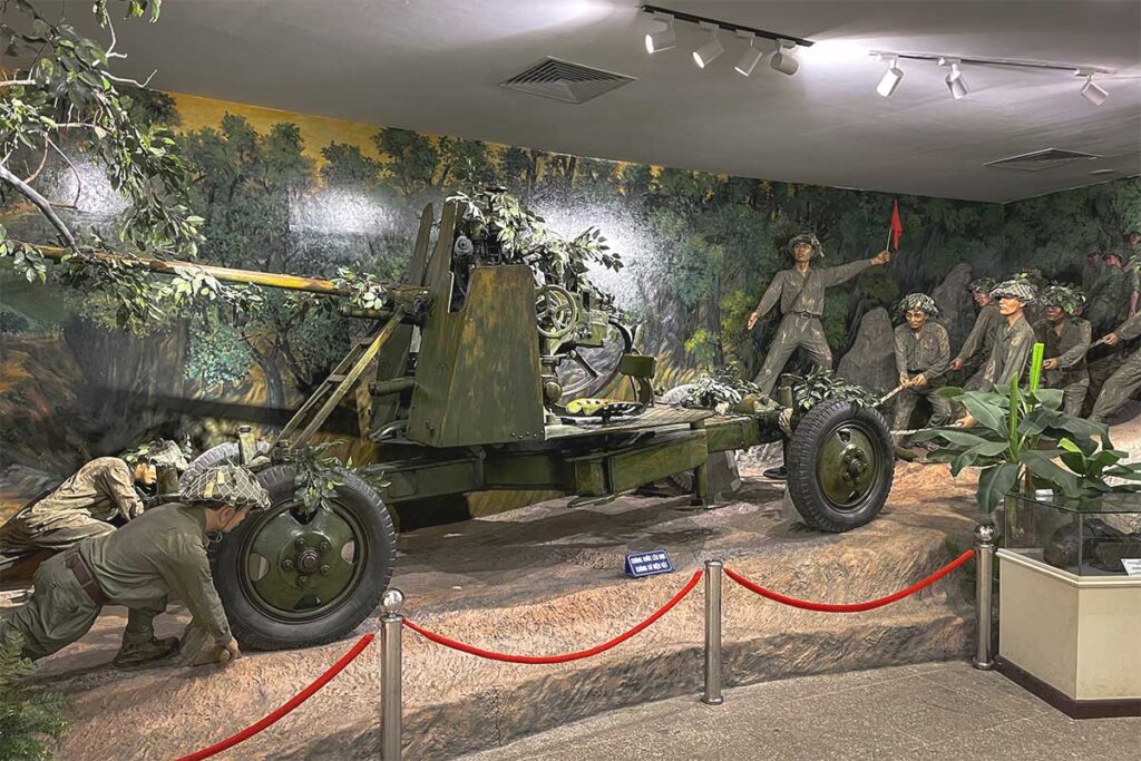 A realistic display inside the Dien Bien Phu Victory Museum, showing Vietnamese soldiers sitting inside a trench, recreating scenes from the battlefield.