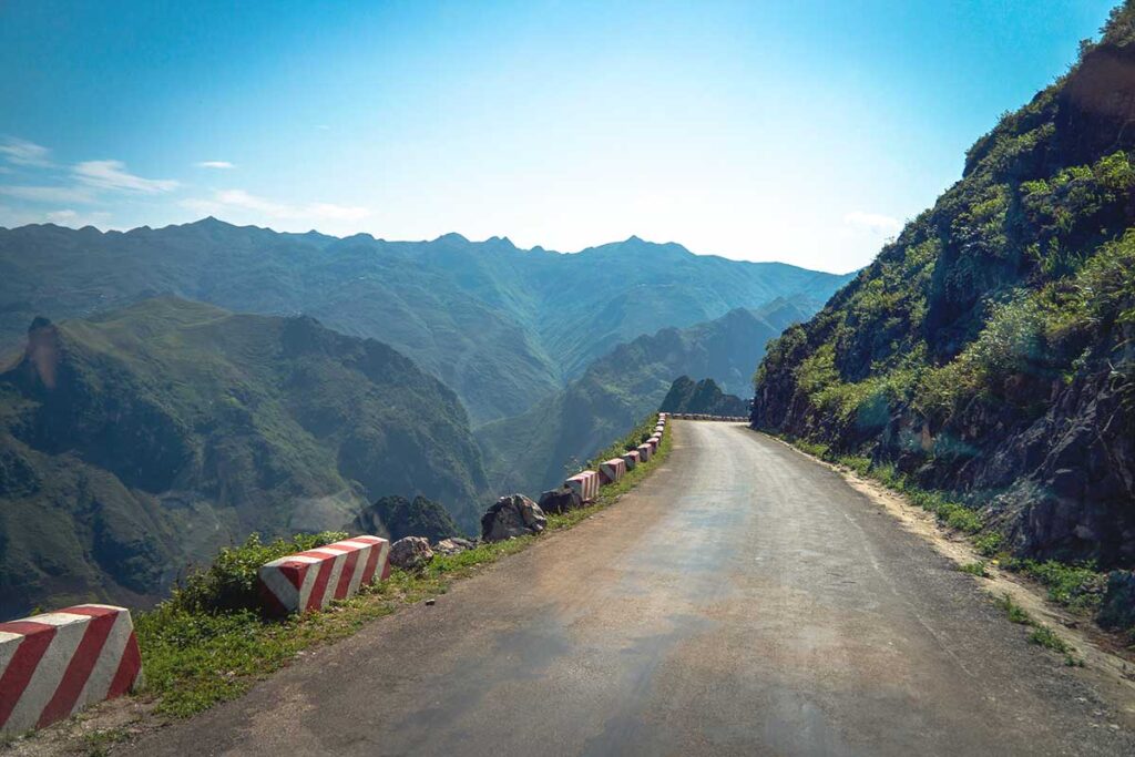 Ha Giang Loop in May – The steep, winding road of Ma Pi Leng Pass on a clear sky day, offering breathtaking mountain views along the Ha Giang Loop in May.