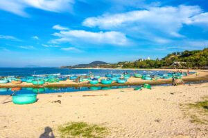 Mui Ne in May: A peaceful beach in Mui Ne in May, where traditional Vietnamese basket boats rest on the shore under sunny skies, reflecting the region’s fishing heritage.