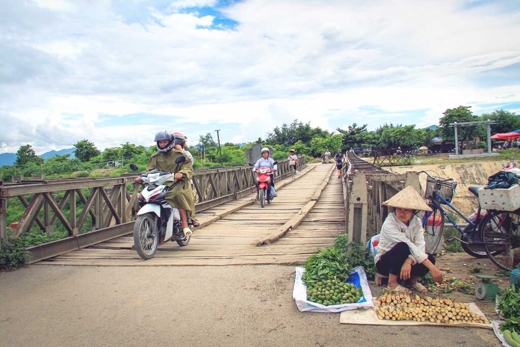 ​Motorcyclists crossing the wooden Muong Thanh Bridge, a historical structure in Dien Bien Phu.​