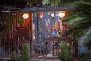 Lanterns glowing at the wooden entrance of Ong Kiet’s Ancient House in Cai Be, Tien Giang, highlighting the historic interior and carved furniture of this Mekong Delta heritage site.