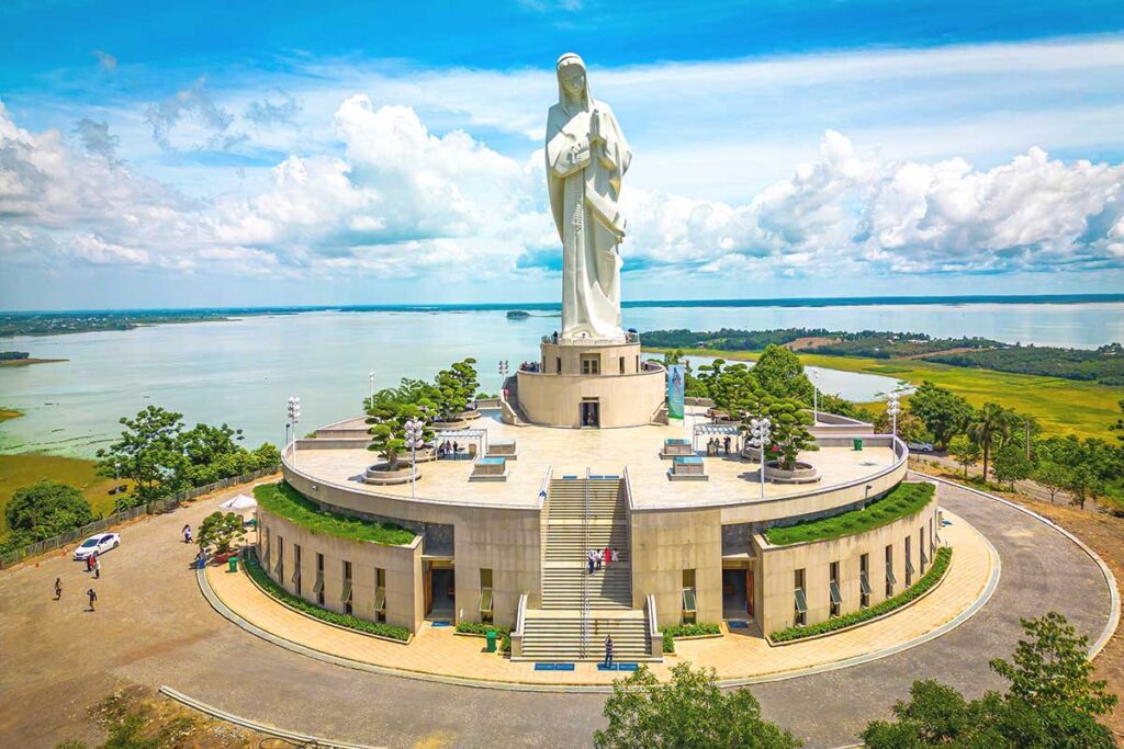 A closer aerial perspective of the Our Lady of Nui Cui statue, showcasing its detailed structure and serene setting.