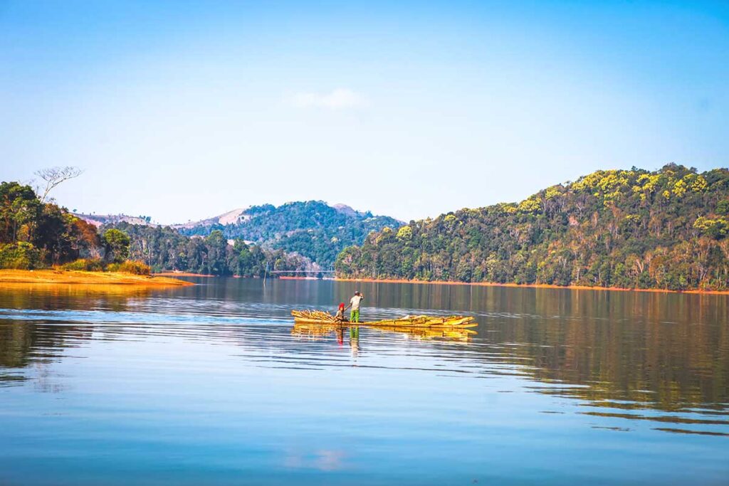 Two local villagers paddling a self-made wooden raft across Pa Khoang Lake, showcasing traditional fishing practices.