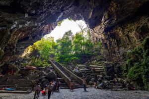 Massive entrance of Huong Tich Cave with steps leading down into the sacred site