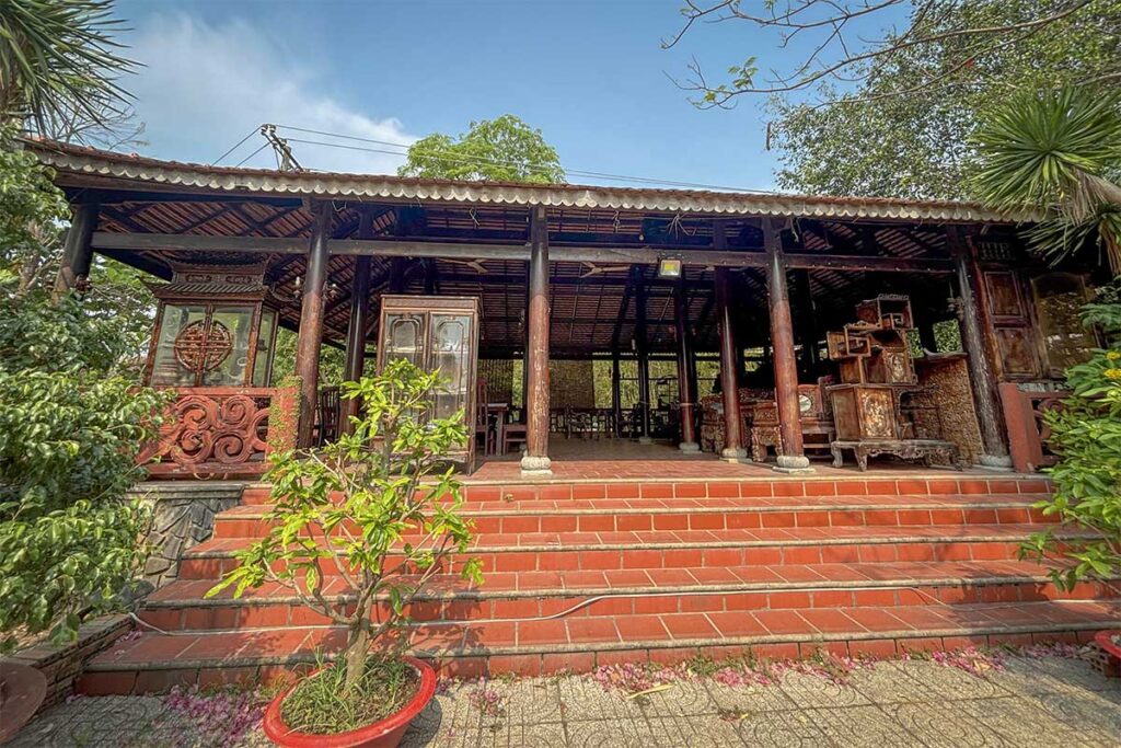 Traditional wooden house with tiled roof at Phuoc Loc Tho Ancient Village in Long An, Vietnam – a cultural heritage site showcasing southern architecture.
