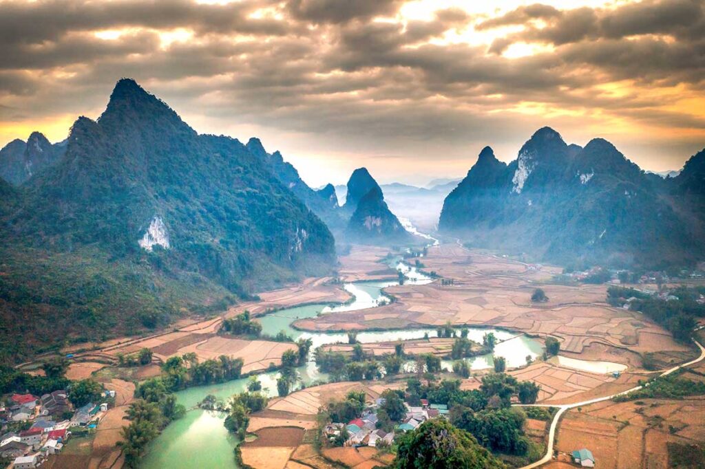 Phong Nam Valley in Winter – A cool and cloudy day in Phong Nam Valley, with misty skies and dry fields, capturing the quiet and subdued beauty of winter in Cao Bang.