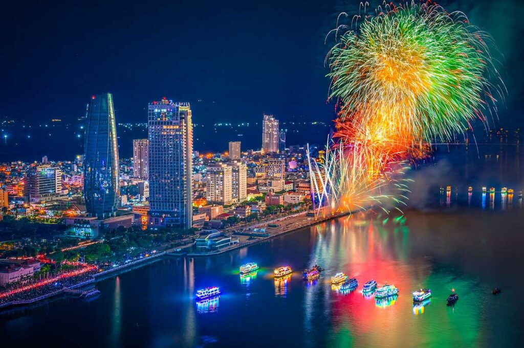 Da Nang in July – A spectacular fireworks show during the Da Nang International Fireworks Festival, with reflections on the Han River and cruise boats watching.