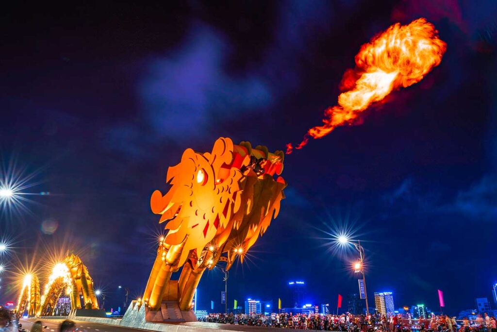 Dragon Bridge in Da Nang breathing fire, with a large crowd gathered on the bridge to watch this popular weekend spectacle.