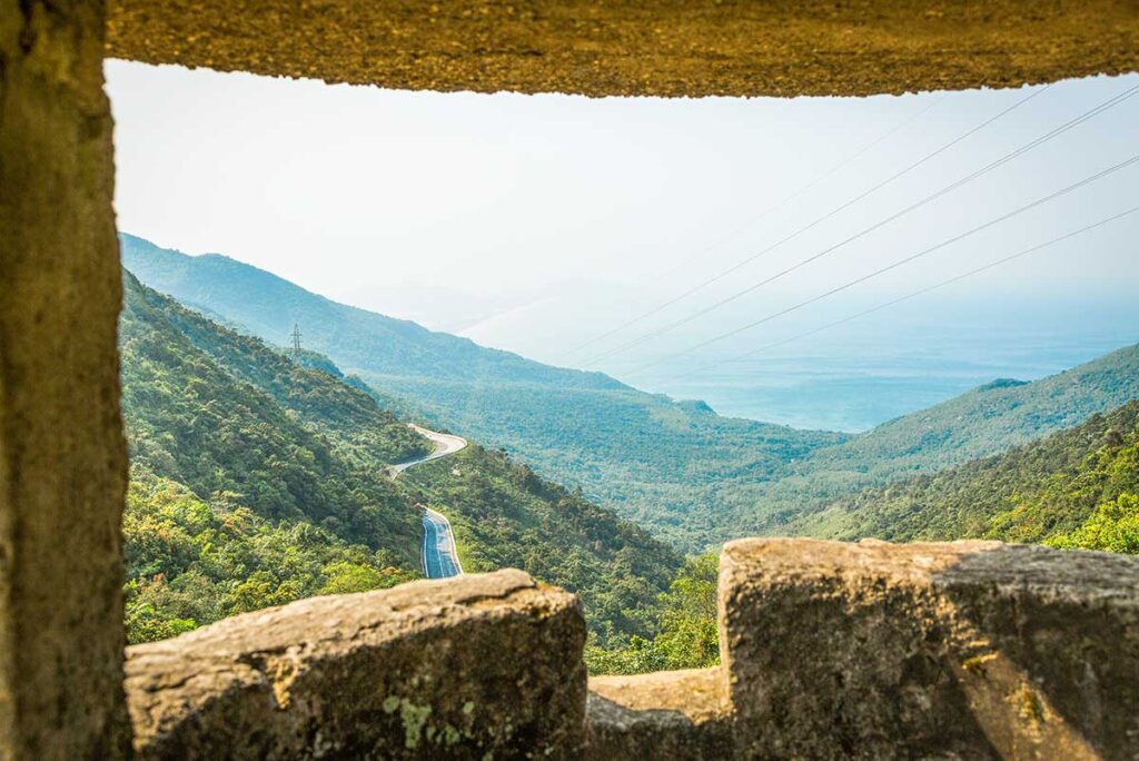 Inside the Bunker Overlooking Hai Van Pass – A unique perspective from inside the old military bunker atop Hai Van Pass, framing a breathtaking view of the winding road and coastline below.