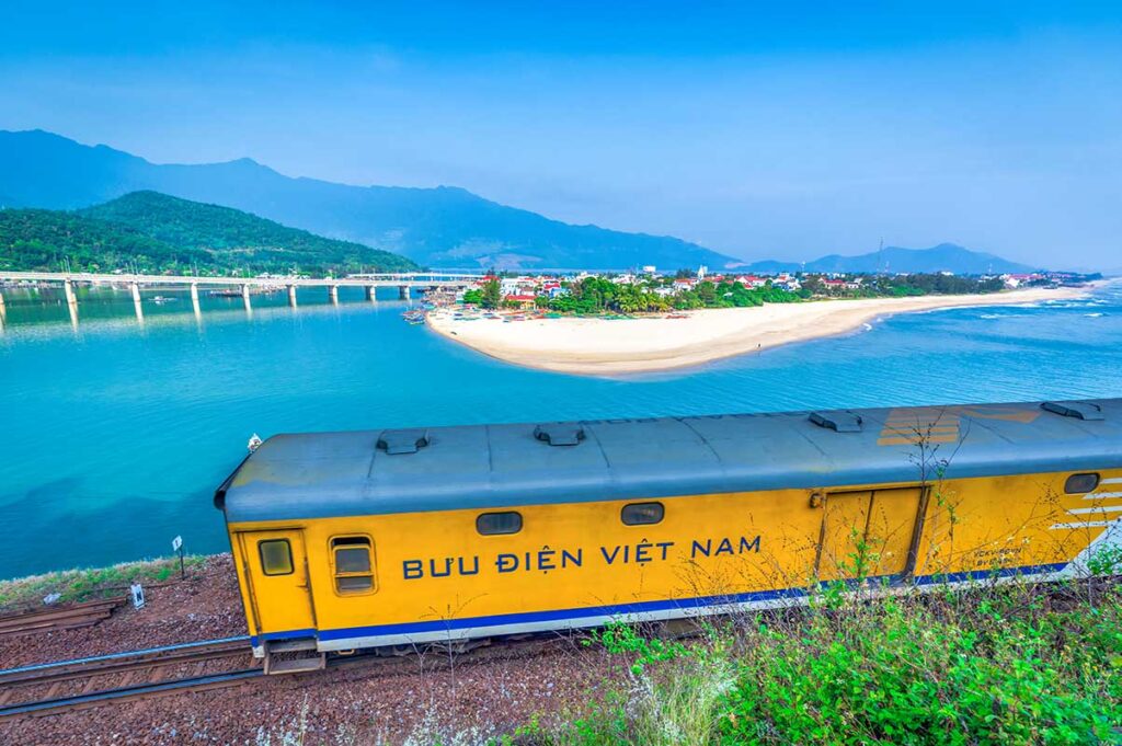 : A train traveling along the Hai Van Pass from Da Nang to Hue, passing a scenic viewpoint overlooking Lang Co Beach and the coastline.