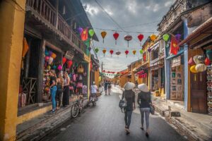 Colorful lanterns and visitors exploring Hoi An Ancient Town in February, when the weather starts warming up and the streets regain a lively, festive atmosphere after the winter rains.
