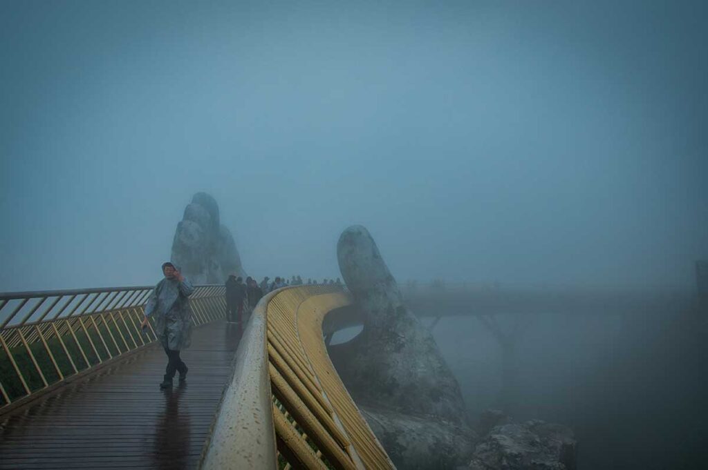 Visitors walking across the Golden Bridge near Da Nang on a misty February day — a reminder that Hoi An’s nearby mountains can still be foggy and cool at the end of winter.