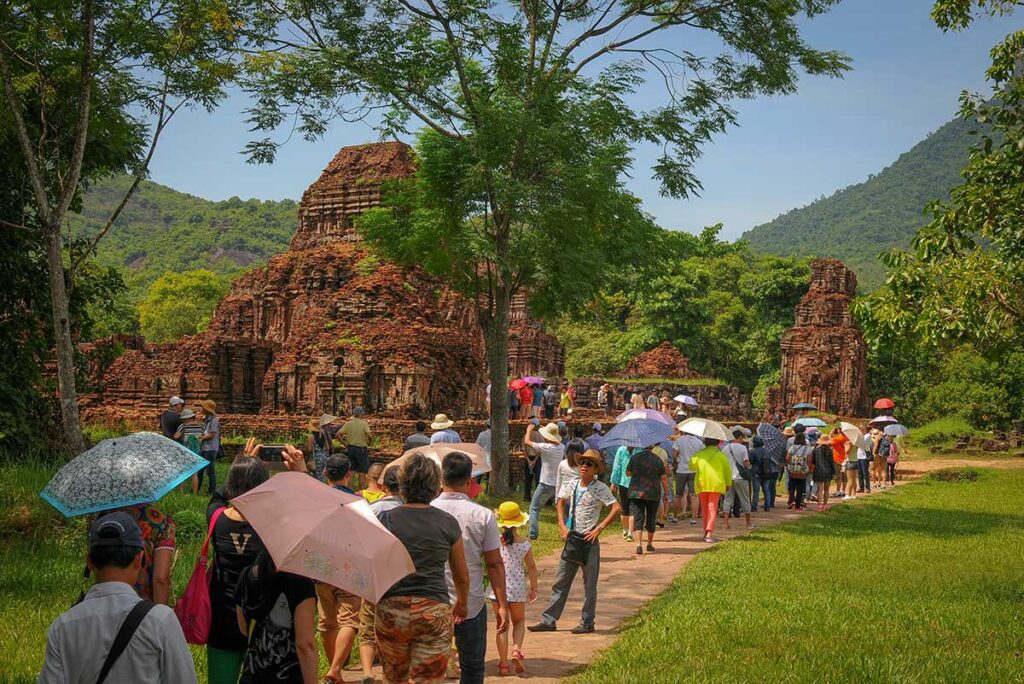 Visitors exploring the ancient My Son Sanctuary near Hoi An under the strong June sun, highlighting the hot and humid conditions of central Vietnamβs summer months.