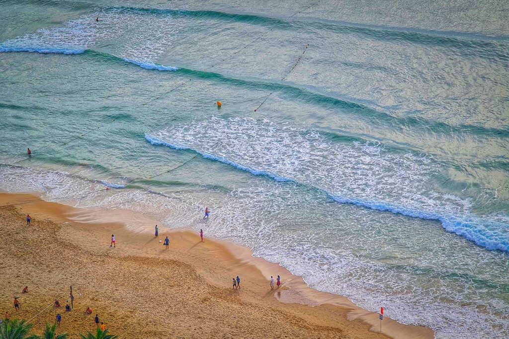 People swimming and walking along Hoi Anβs beaches in June, when the sea is warm and the heat encourages cooling off in the water during the peak of summer.