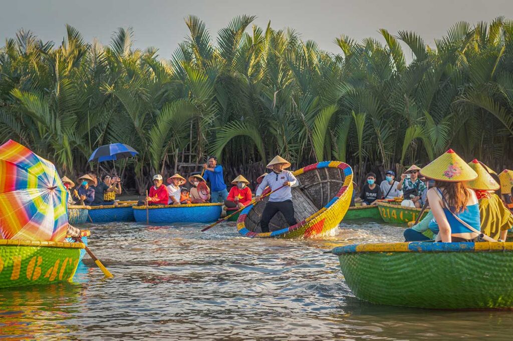 Tourists enjoying basket boat rides in Hoi Anβs Coconut Village in June, when sunny weather and high temperatures make early morning tours the most comfortable time to explore.