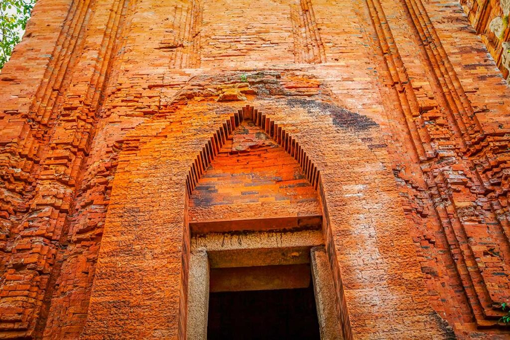 Cham Twin Towers entrance detail – Pointed arch doorway framed by textured brick patterns, showing the craftsmanship of Cham builders.