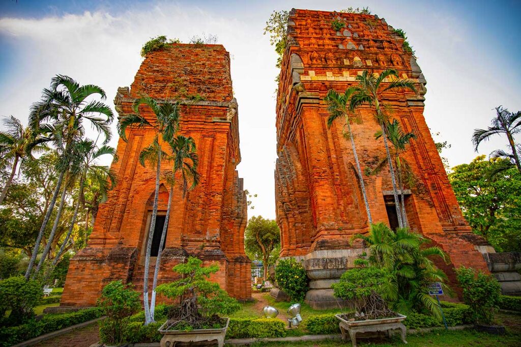 Cham Twin Towers at sunset light – Warm tones highlighting the historic red brick structures surrounded by tropical greenery.