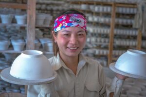 A woman holding two bowls at Chu Dau Ceramic Village