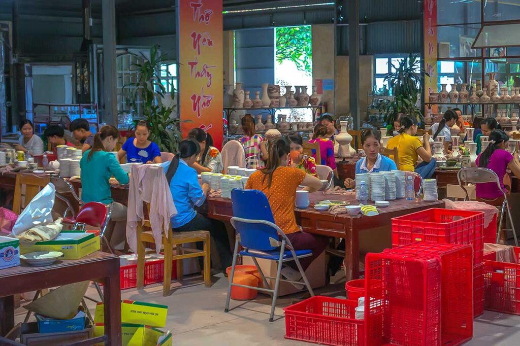 Local woman working at a workshop painting on ceramics at Chu Dau Village