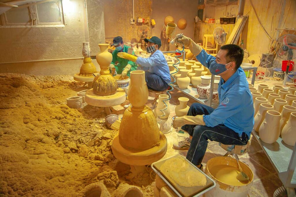 People busy making ceramics on traditional ways at Chu Dau Ceramic Village