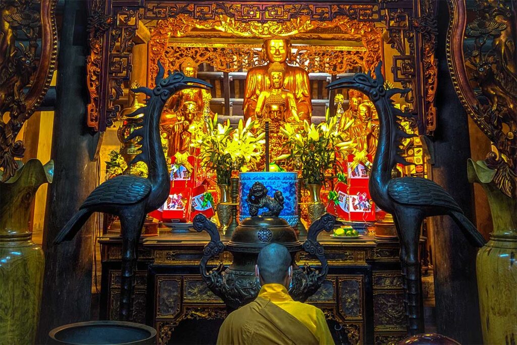 A buddhist monk praying at an altar inside Con Son Pagoda