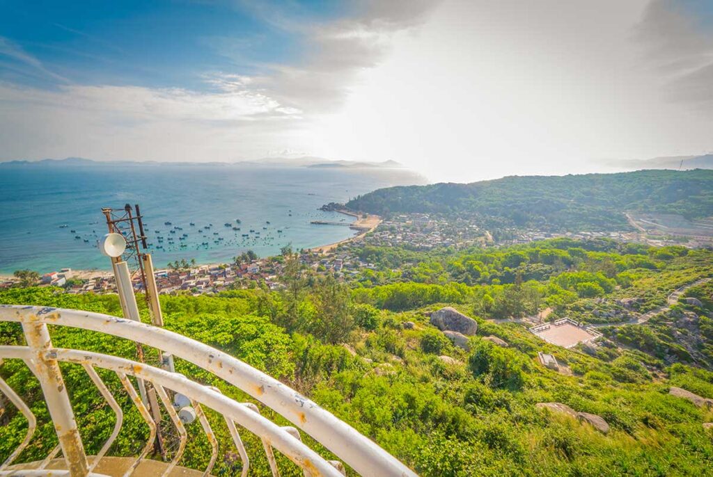 Panoramic view of Cu Lao Xanh Island from the lighthouse, showing the fishing village, coastline, and moored boats off Quy Nhon.