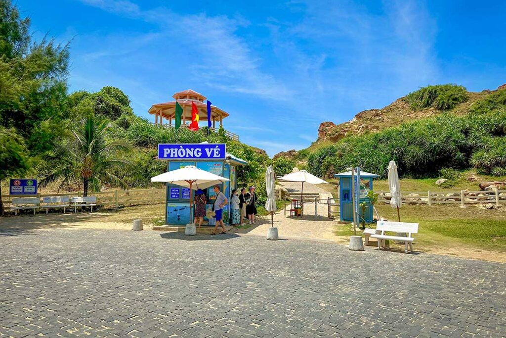 Ticket booth and shaded umbrellas at the official entrance gate of Eo Gió, Quy Nhon