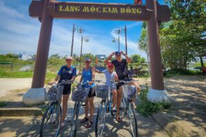 Hoi An Cycling Tour – group photo at the entrance of Kim Bong carpentry village on Cam Kim Island