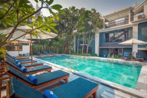 Aira Boutique Hoi An Hotel pool area near An Bang Beach, featuring blue sunbeds and a peaceful tropical setting.