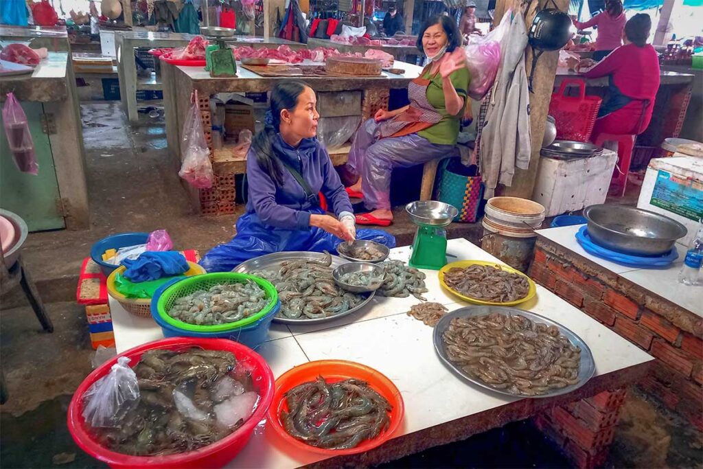 Local seafood vendors selling fresh shrimp and fish at An Bang Market in Hoi An.