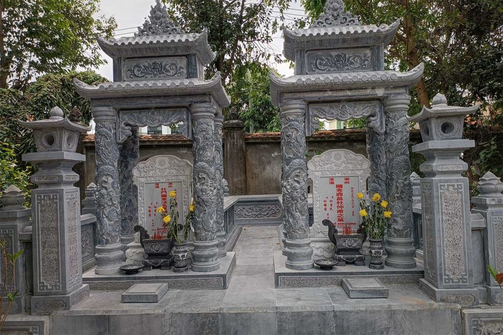 Stone ancestral tombs with intricate carvings and red inscriptions at Chuc Thanh Pagoda Hoi An