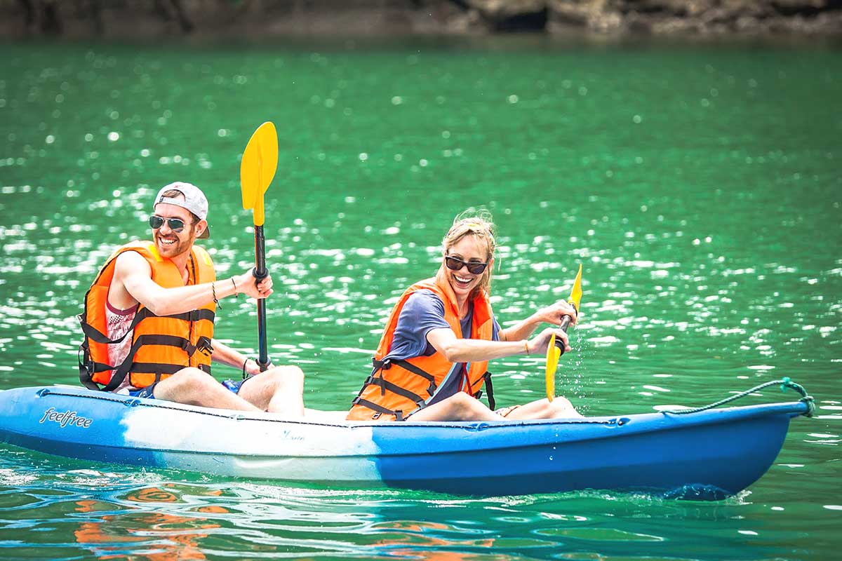 A group of friends kayaking through Lan Ha Bay