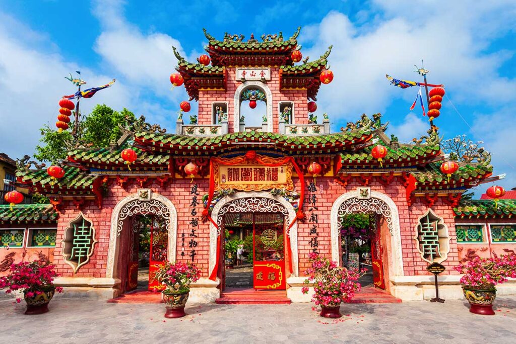 Front gate of Fujian Assembly Hall in Hoi An, featuring Chinese architecture, green-tiled roof, and red lanterns