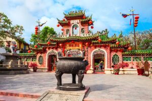 Close-up view of the richly decorated gateway of Fujian Assembly Hall, Hoi An, with incense urn in the courtyard.