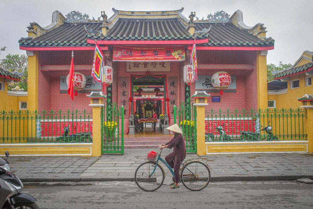 Front facade of Hai Nam Assembly Hall Hoi An with green gates and tiled roof – vibrant temple entrance along the historic streets of Hoi An Ancient Town.