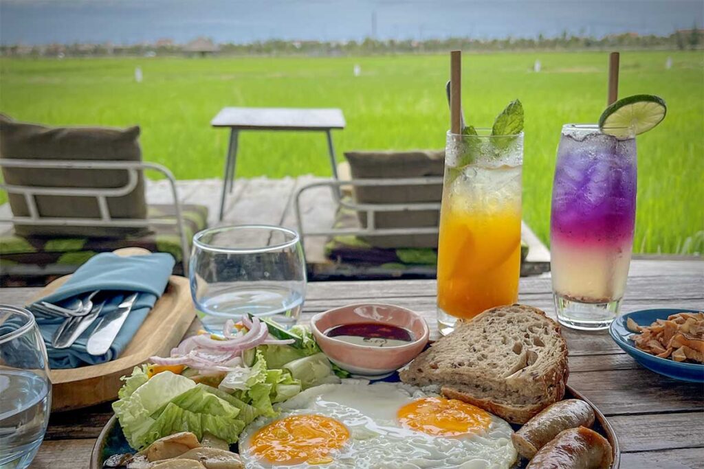 Breakfast with fresh juice and eggs overlooking rice fields – relaxing countryside cafe experience in Hoi An.