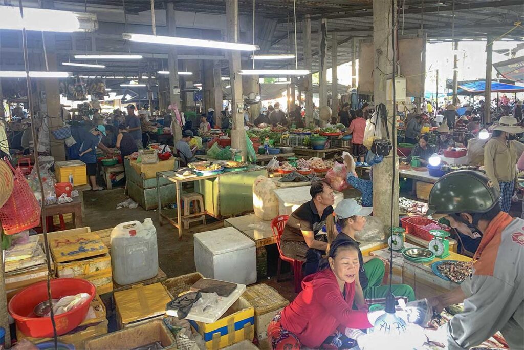 Busy morning at Thanh Ha Market – Local vendors sell fresh produce and seafood under the covered market hall, offering travelers an authentic look at daily life in Hoi An.