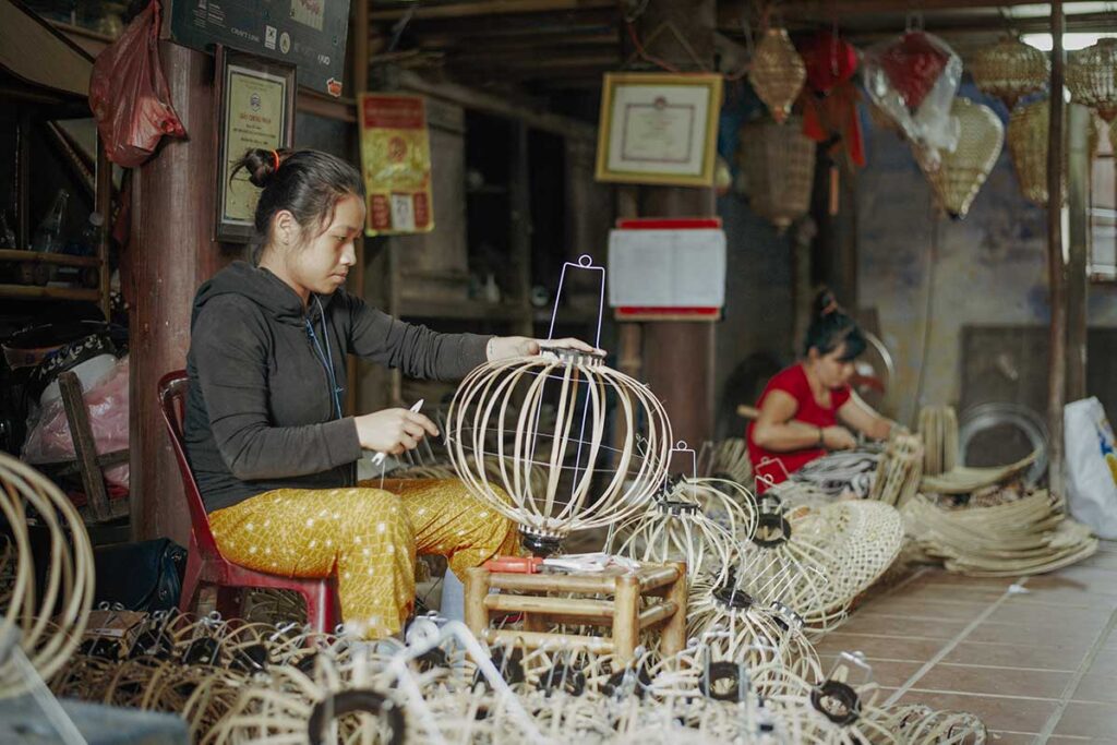Local artisans crafting bamboo frames in a traditional lantern making workshop in Hoi An.