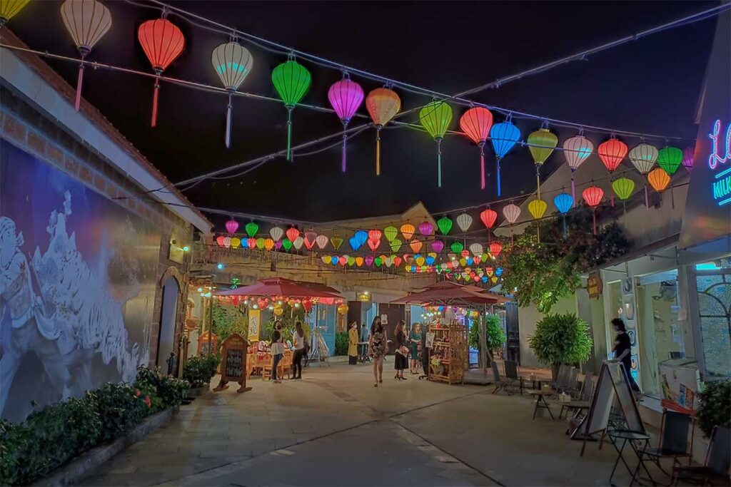 Colorful lanterns hanging above the streets inside Hoi An Memories Land at night.